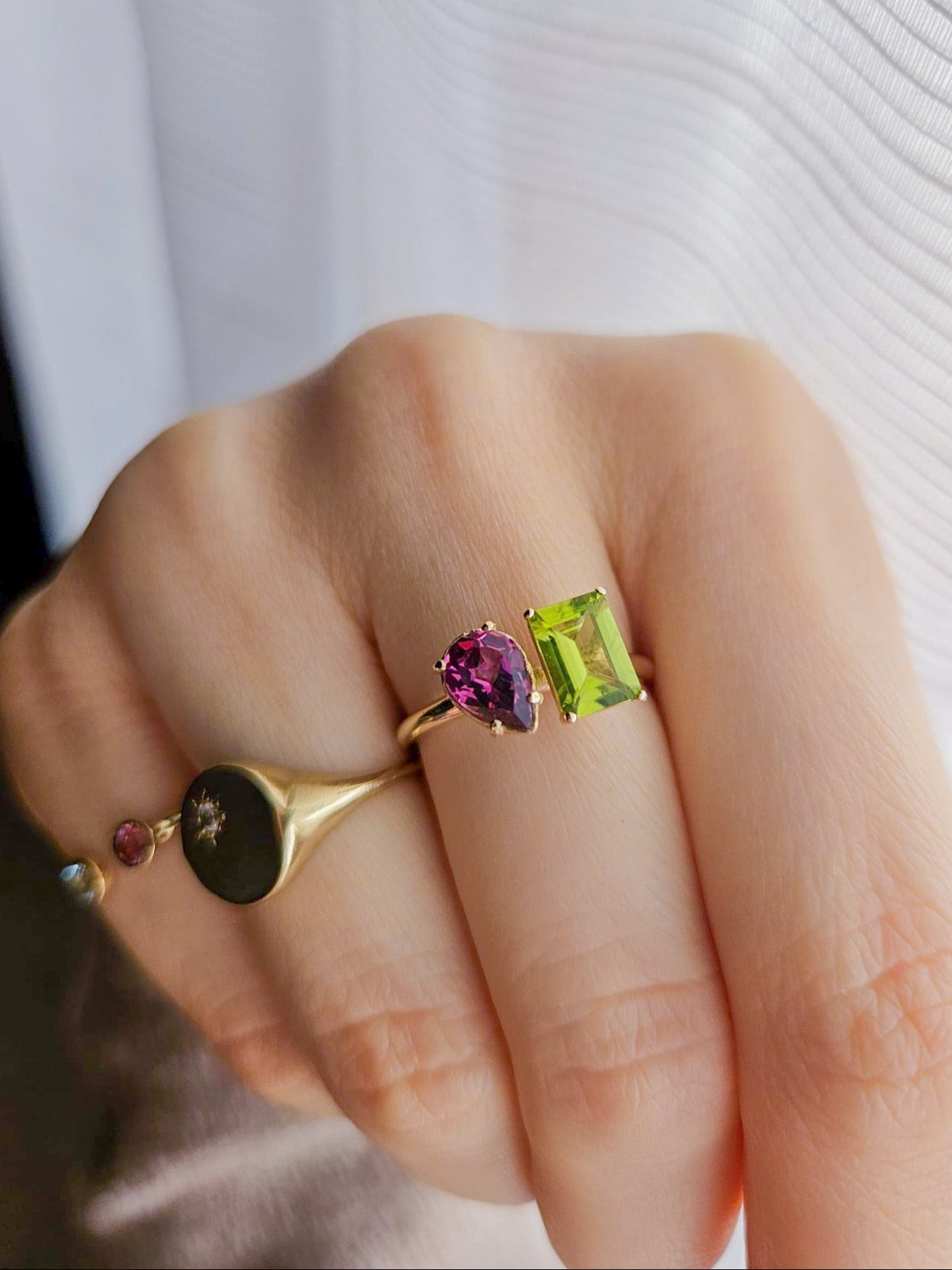 Anelli personalizzati in oro giallo con gemme semipreziose naturali, indossati dalla cliente. Design e realizzazione di Aurora Bariletti.