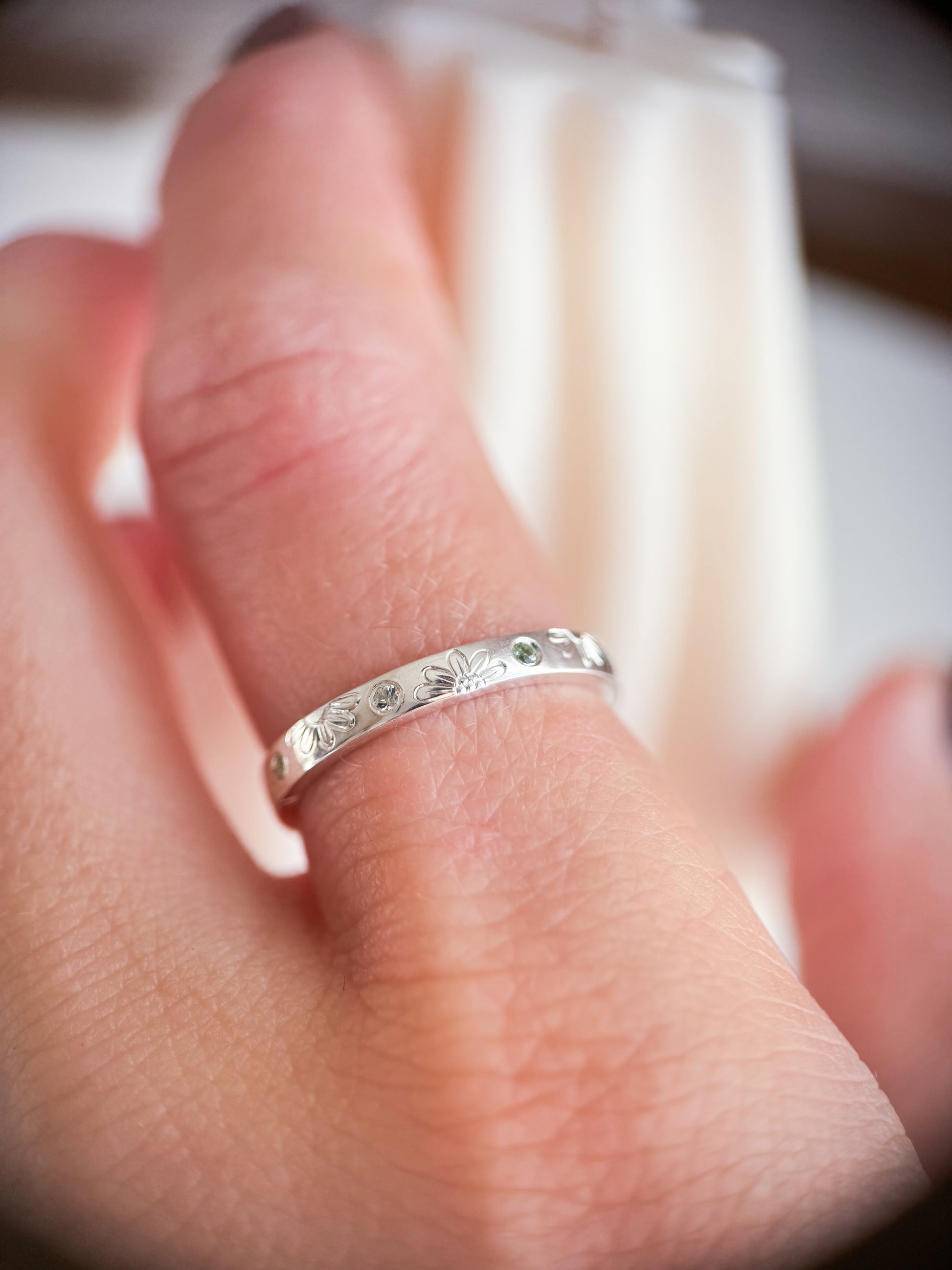 Anello artigianale Aurora Bariletti in argento 925, inciso a mano con margherite e zaffiri verdi dello Sri Lanka.