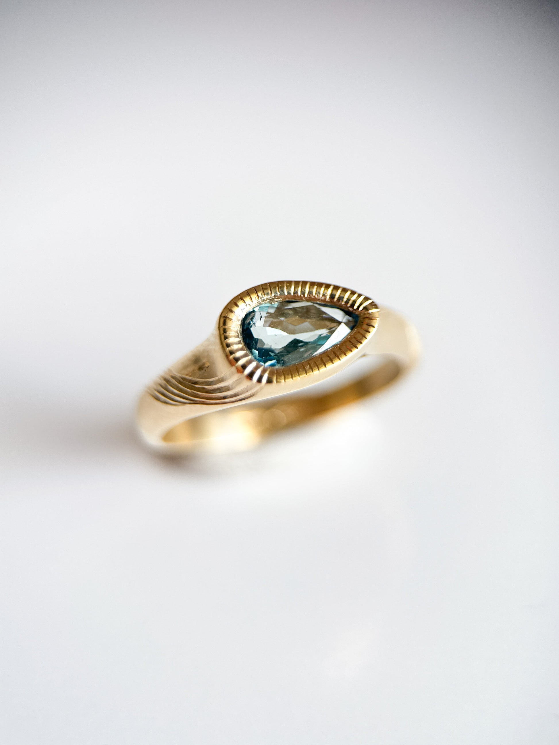 Anello in oro giallo 9kt e acquamarina taglio a goccia con incisioni luminose fatte a mano. Gioiello esclusivo creato da Aurora Bariletti nel suo laboratorio a riva del garda, italia.