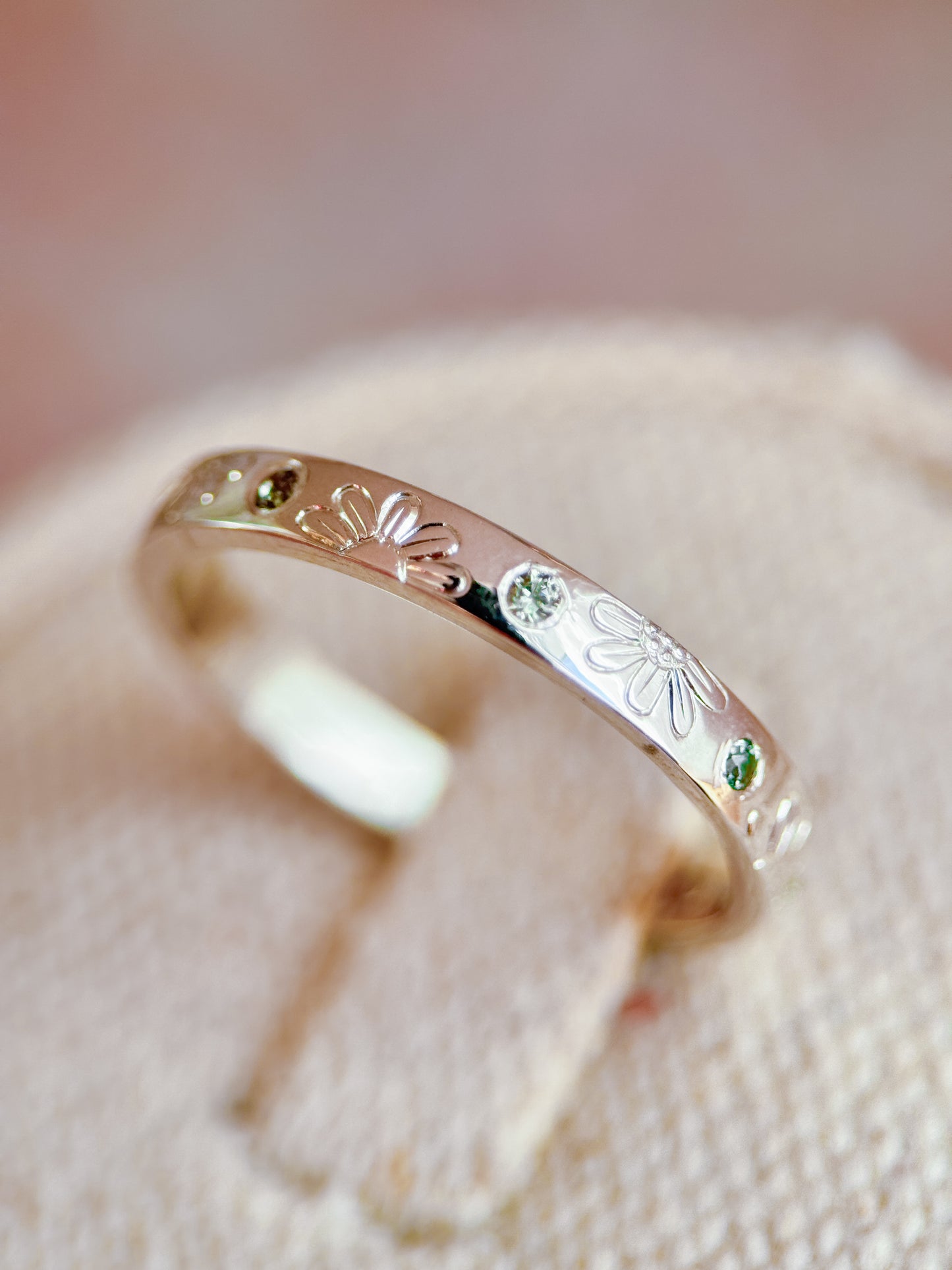 Anello artigianale Aurora Bariletti in argento 925, inciso a mano con margherite e zaffiri verdi dello Sri Lanka.