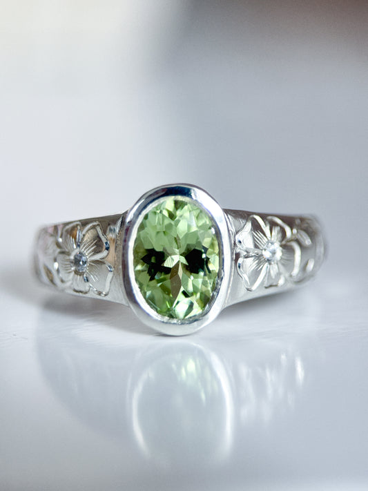 Anello in argento 925 con tormalina verde ovale e incisioni floreali eseguite a mano sul gambo. Realizzato da Aurora Bariletti nel suo laboratorio a riva del garda, italia.