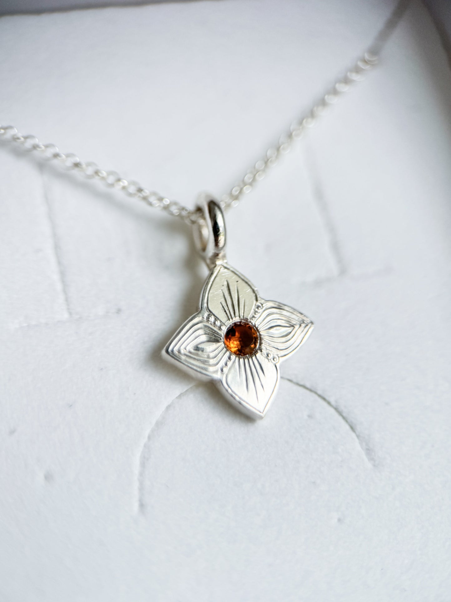 Pendente realizzato a mano libera da Aurora Bariletti, con quarzo citrino al centro. I tagli obliqui sui petali giocano con la luce, creando un piccolo gioiello luminoso e unico.