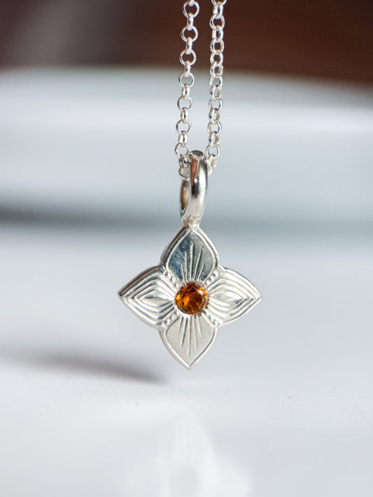 Pendente realizzato a mano libera da Aurora Bariletti, con quarzo citrino al centro. I tagli obliqui sui petali giocano con la luce, creando un piccolo gioiello luminoso e unico.