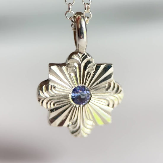 Video pendente inciso a mano libera da Aurora Bariletti, con tanzanite al centro. I tagli dritti e curvi evocano la forma di un fiocco di neve.