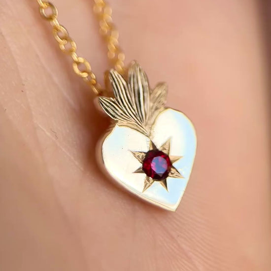 Video della collana con cuore sacro in oro giallo 9kt e granato rosso incastonato a stella. Gioiello esclusivo creato da Aurora Bariletti nel suo laboratorio a riva del garda, italia.