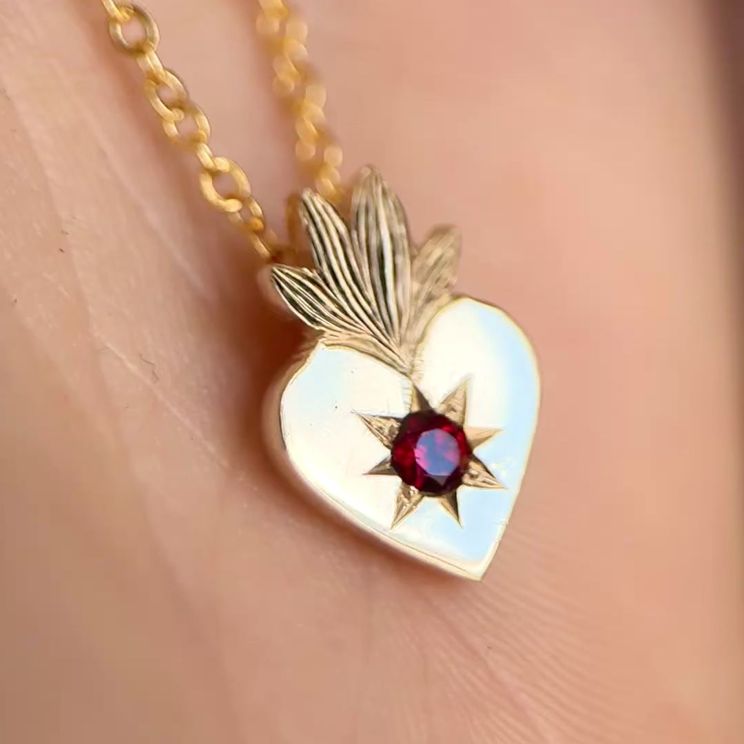 Video della collana con cuore sacro in oro giallo 9kt e granato rosso incastonato a stella. Gioiello esclusivo creato da Aurora Bariletti nel suo laboratorio a riva del garda, italia.